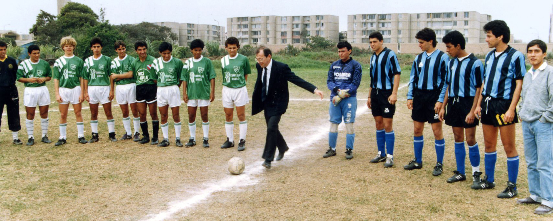 Autoridad pateando el balón junto a alumnos.