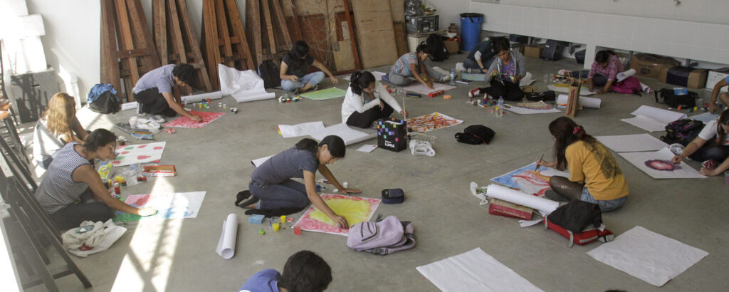 Alumnos trabajando cursos de arte en el suelo de EE.GG.LL.