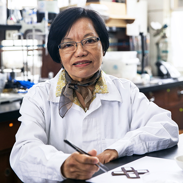 La profesora Rosario Sun posa en un laboratorio de qímica. usa bata blanca, pelo corto y anteojos