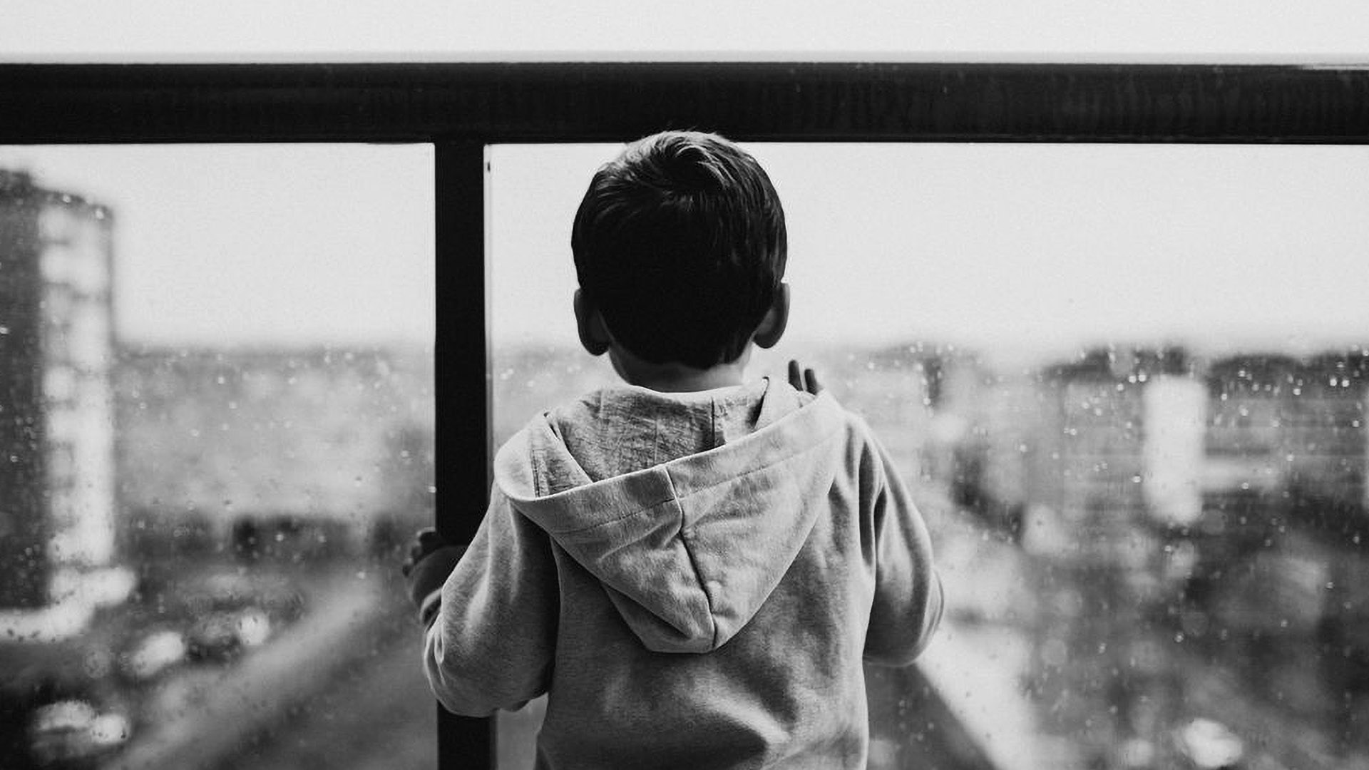 Niño asomado en un balcón.