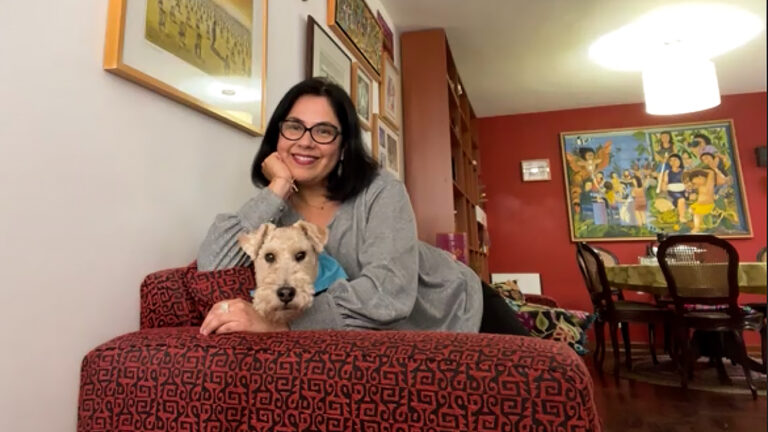 La profesora makena ulfe en su sala posa en un sofá rojo junto a su perrito