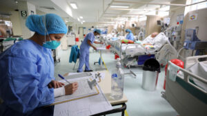 Sala UCI con varias camas con pacientes atendidos por personal de salud