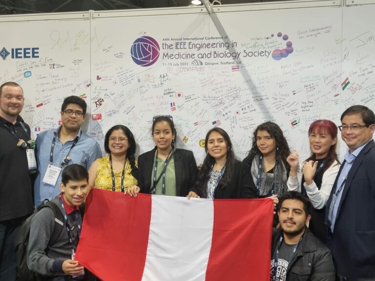 Foto de los estudiantes PUCP-UPCH con bandera peruana en el congreso más importante de Ingeniería Biomédica a nivel mundial