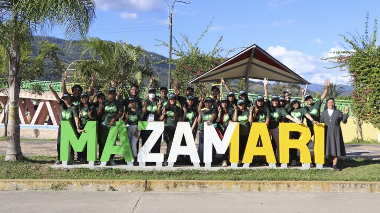 foto grupal de los integrantes de las misiones universitarias del capu: más de 20 jóvenes con polo verde detrás de unas letras que dicen Mazamari, de aprox 1 metro de altura.
