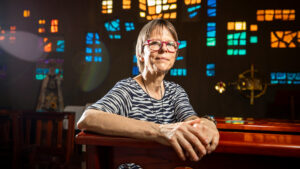 Birgit Weiler sentada en una banca dentro de la iglesia del CAPU