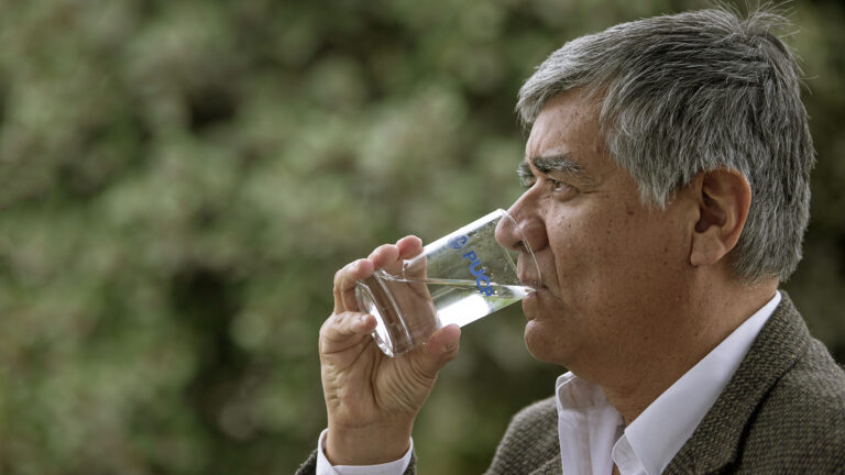 Fernando Jimenez tomando un vaso de agua que pasó por su purificador de agua contaminada