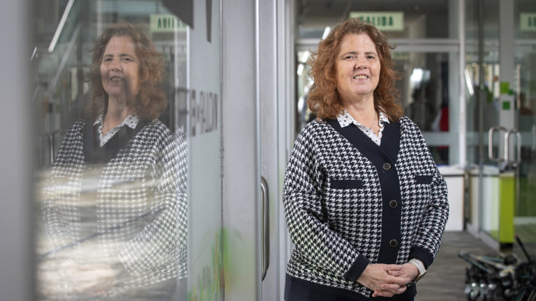 Foto de Mónica Roque, especialista en políticas para adultos mayores: una señora de aprox 45 o 50 años, blanca, de pelo largo naranja. lleva una blusa celeste y una choma negra de botones con aplicaciones blancas