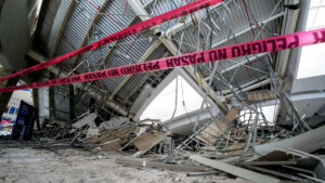 Real Plaza de Trujillo tras el colapso: muestra los escombros del techo desplomado y, en primer plano, cintas rojas que dicen "peligro" para restringir el acceso.