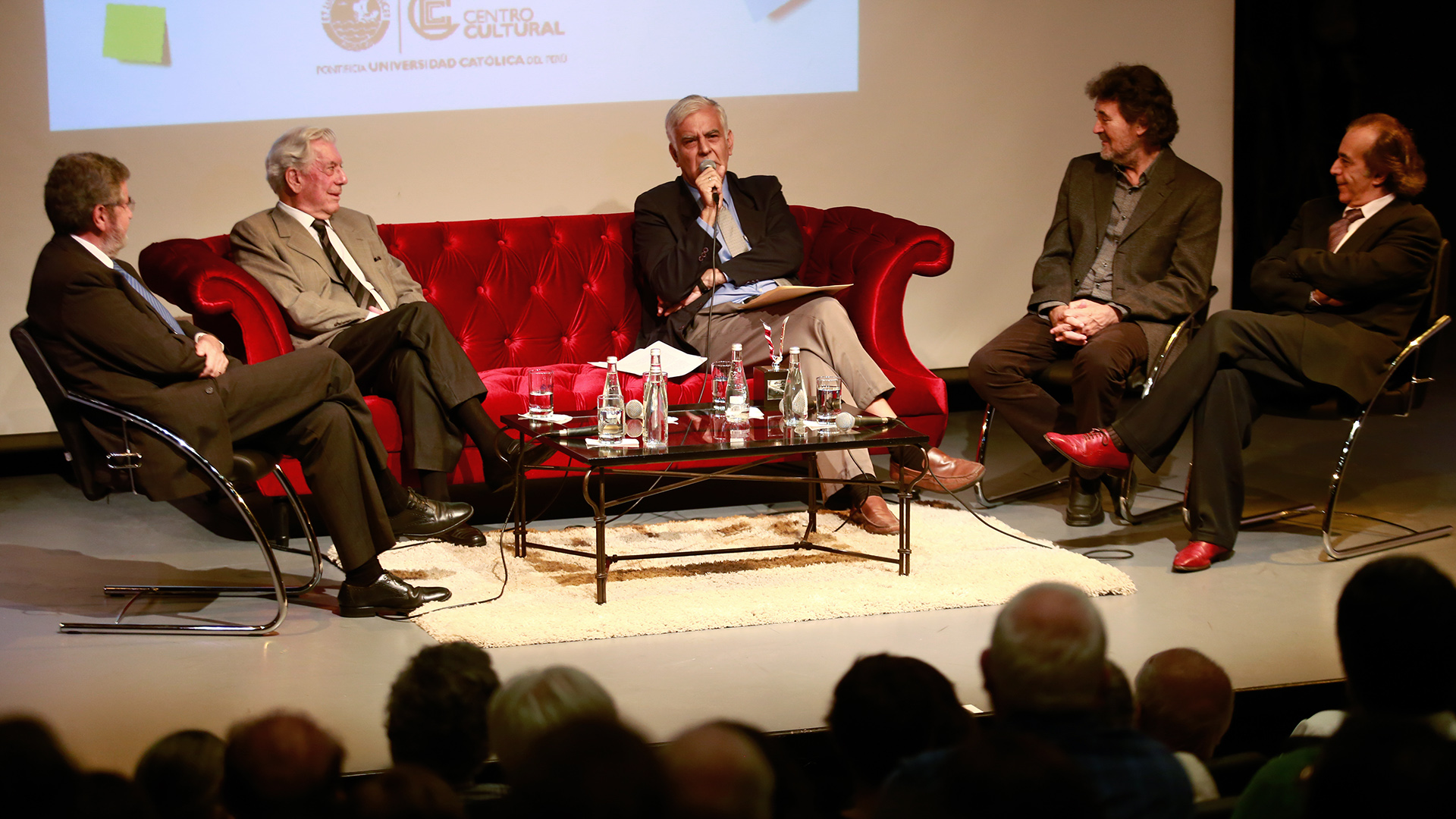 Sobre el escenario, en un sillón, Cueto se encentra rodeado por Efraín Gonzáles de Olearte, Mario Vargas Llosa, Francisco Lombardi y Edgar Saba.