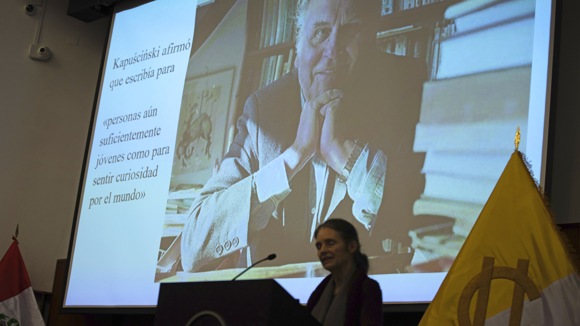 Un imagen de Rysard Kapuściński detrás de la Dra. Alkire.