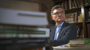 José de la Puente Brunke, sentado frente a su escritorio lleno de libros.